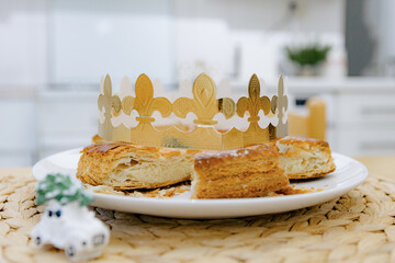A cut royal galette with a golden crown on the table.