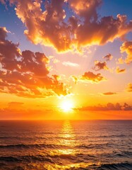 Fototapeta premium Stunning sunset over ocean, clouds ablaze with golden hues, reflecting on water