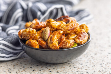Nuts coated in sugar glaze in bowl on kitchen table.