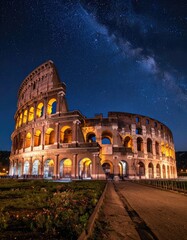 Fototapeta premium Roman Colosseum bathed in warm light under a stunning, starry night sky