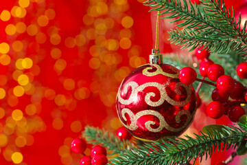 Beautiful ornaments on Christmas tree against red background with blurred lights, closeup and space for text. Bokeh effect