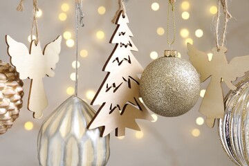 Obraz premium Beautiful Christmas decor hanging on string against blurred lights, closeup