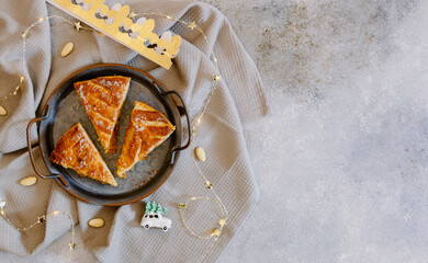 Three pieces of galette on a rustic metal plate on the table.