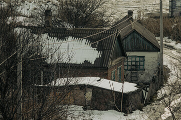 Old brick house, tangled wires and trees in quiet snowy suburb