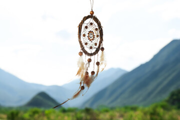 Dream catcher with feathers and beads in mountains