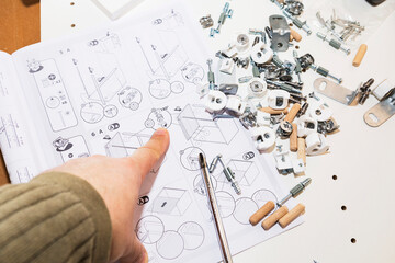 Hands craft puzzle, Individual configuring miniature wooden pegs on smooth surface, Detailed shot...