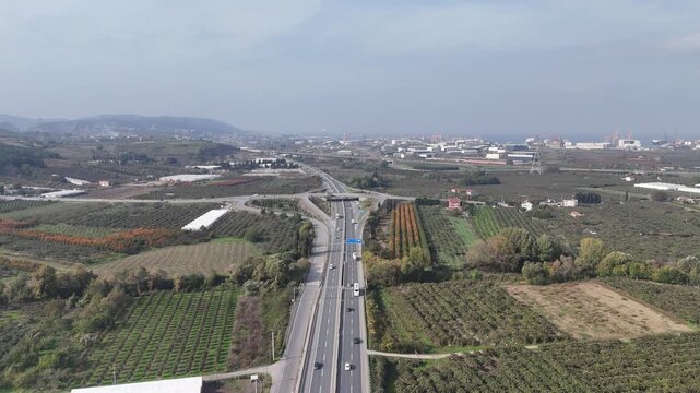 A highway view overlooking the city of Termal in Yalova Province, Turkey, showing a modern fast road passing near urban areas and natural surroundings. The scene captures moving vehicles, city buildin