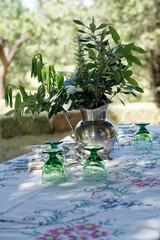 Outdoor table setting with silver pitcher and green glass