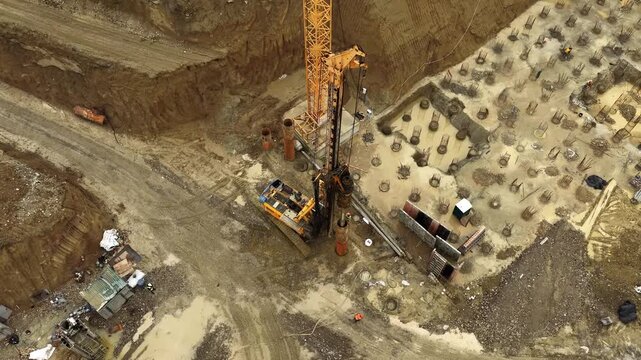 Drilling rig rotating auger over muddy foundation with reinforcement piles
