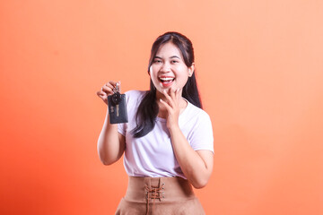 Cheerful asian woman holding and showing car key with happy face expression for car business...