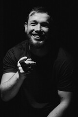 Portrait of a handsome young man. Expressive joyful emotion, friendly gesture, casual style and warm atmosphere.