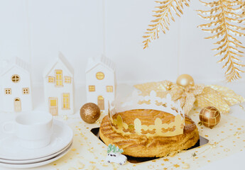 Fresh royal galette with crown and plates lie on the table.
