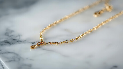 Close up shot of a delicate gold chain necklace on a white marble surface in soft natural lighting