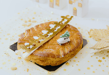 Almond royal galette with crown and surprise lies on the table.