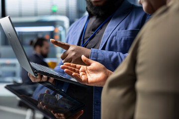 African American team of analysts collaborating in a solar tech factory, demonstrating inclusive teamwork and innovation for the production process. Industrial manufacturing at a plant.