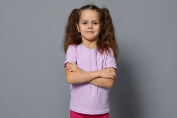 Portrait of cute little girl on grey background