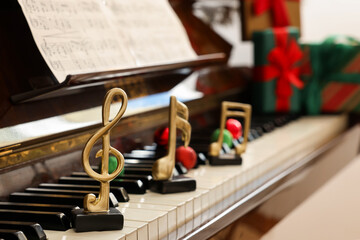 Christmas atmosphere. Golden music notes and baubles on piano indoors