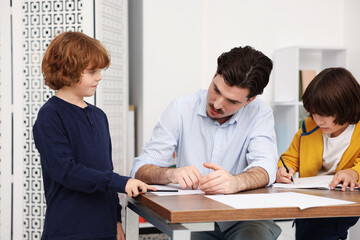 Teacher helping student during lesson in classroom