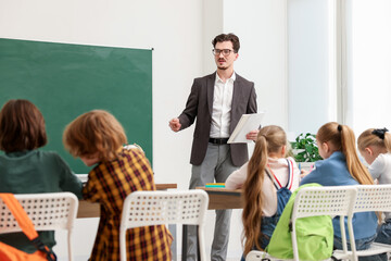 Children listening teacher during lesson in classroom