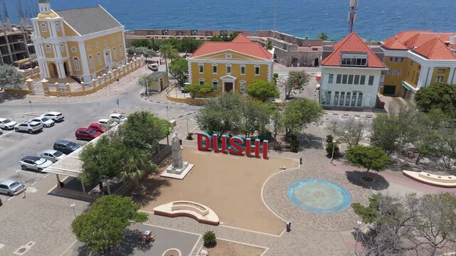 Aerial view of Willemstad square with &ldquo;DUSHI&rdquo; and &ldquo;CURA&Ccedil;AO&rdquo; signs facing the Caribbean Sea