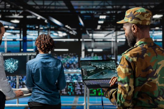African american army officer in control center server room using AI systems to detect cyber threats. Military data center personnel uses software to secure national safety, anti terrorism.