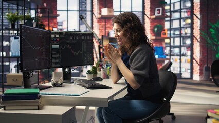 Joyful thrilled woman works on stock trading analysis browsing real time data on her monitors. The digital platform provides financial statistics, forex trends and investment insights. Camera A.