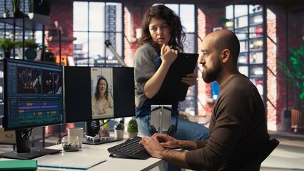 In a tech driven studio, team edits smartphone video footage on a dual monitors setup, applying professional tools for video creation. Targeting algorithm shifts and maximizing engagement. Camera A.