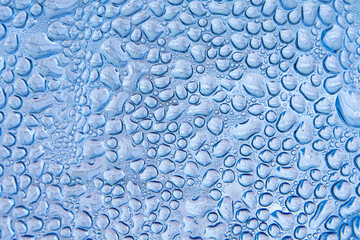 Abstract background featuring a macro view of water droplets on a blue surface, creating a natural pattern of moisture and condensation.