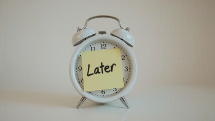 Alarm clock with a sticky note that reads "Later".