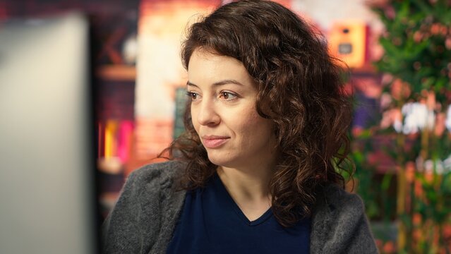 IT specialist at workstation programming on monitor and writing lines of code, using development tools and a terminal window interface. Woman debugging software before deadline. Camera B.