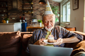 Senior man smiling, celebrating birthday on video call at home