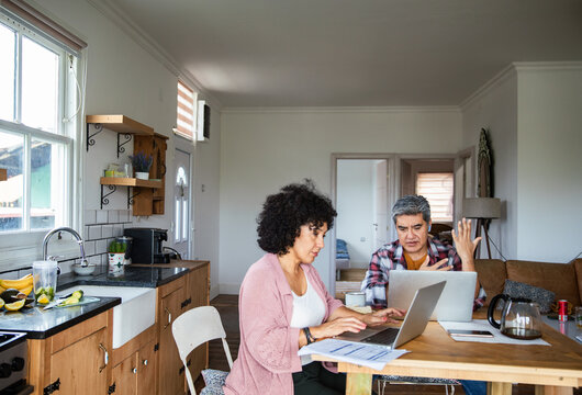 Mature couple worried about bills at home kitchen