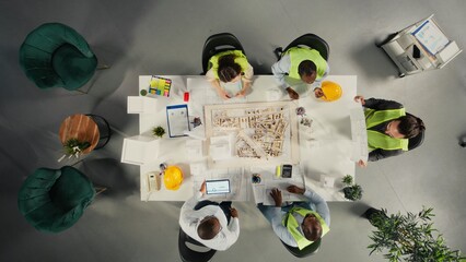 Top down view of architects and engineers collaborating on housing and city planning. Teamwork, innovation and design as real estate experts plan residential project development.