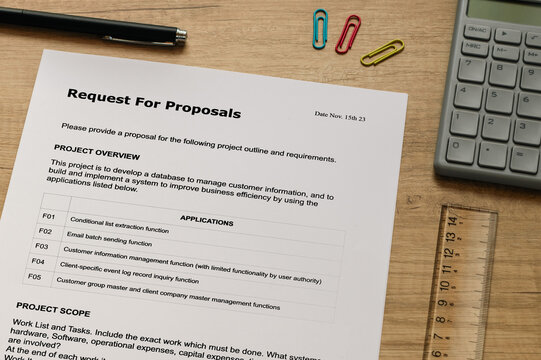 The dummy document of the Request For Proposal is on the desk, along with a calculator and a pen.