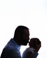Father kissing newborn baby head showing parental love