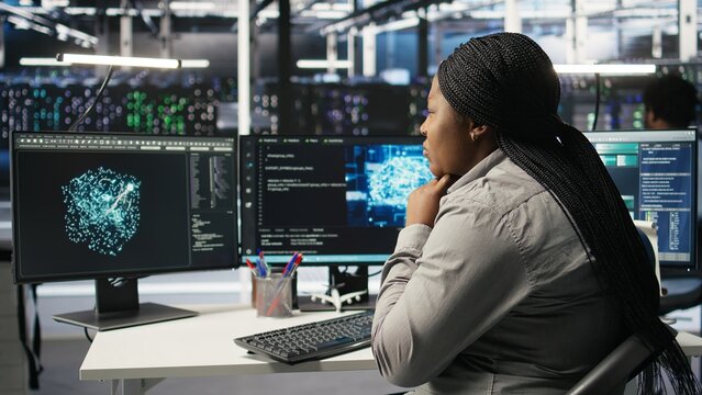 Data center technician using artificial intelligence deep learning models to configure hardware. African american woman works on AI programming language in server room, optimizing system, camera A - Powered by Adobe