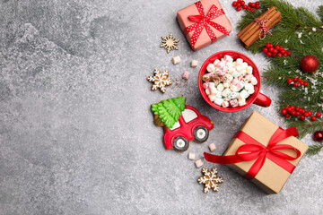 Tasty gingerbread cookies, cup of drink and Christmas decor on light grey table, flat lay. Space for text