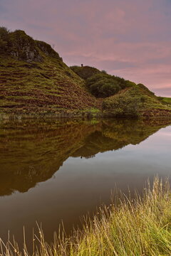Rosy sky of late afternoon lighting the lochan at Fairy Glen, with the basalt outcrop of Castle Ewen reflected in the water. Isle of Skye-Scotland-123