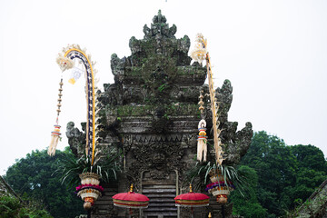 Traditional Balinese Temple Entrance with Penjor and Umbrellas