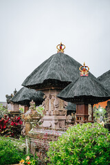 Balinese temple structures with thatched roofs and golden finials