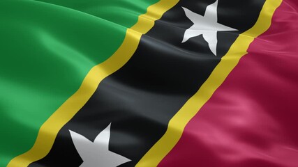 Waving flag of saint kitts and nevis proudly displays its vibrant green, red, black, and yellow colors with two prominent white stars, symbolizing national pride and caribbean identity.
