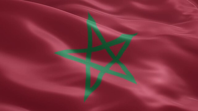 Waving national flag of morocco displaying its iconic red field and green pentagram, symbolizing the rich history, culture, and sovereignty of the north african nation.
