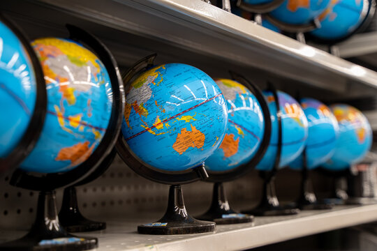 Close-up view of colorful world globes displayed on store shelf.