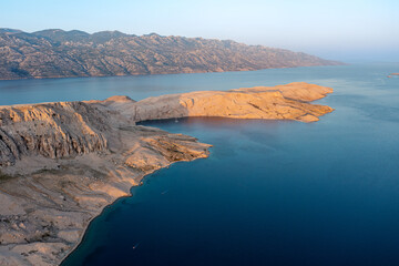 Aerial view of a picturesque bay with a yacht at anchor and islands surrounded by blue sea.