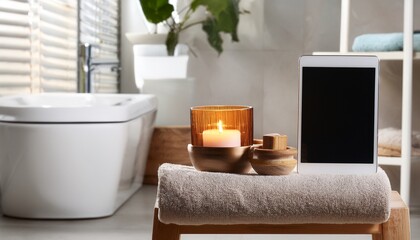 serenity in a modern bathroom with candle and tablet on stool