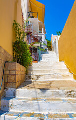 Old white stone staircase between yellow walls, Symi island, Greece