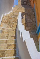 Top view of old  stone staircase with white railing, Symi island, Greece