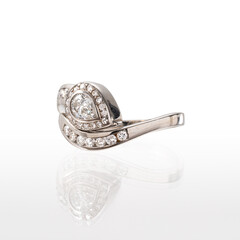 18kt white gold snake-shaped ring with a central pear-shaped diamond and diamond surround. Photographed on a white background with reflection.
