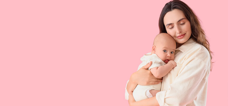 Happy mother with her little baby on pink background. IVF concept