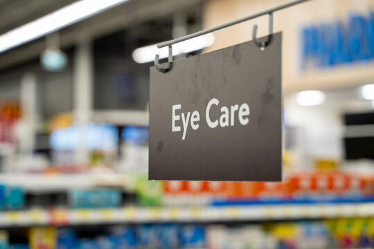 Close up of eye care aisle sign hanging in pharmacy section.